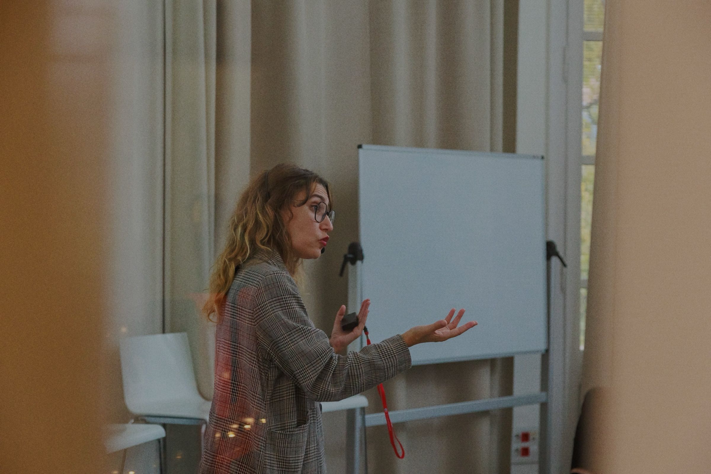 A woman presenting next to a whiteboard during a session